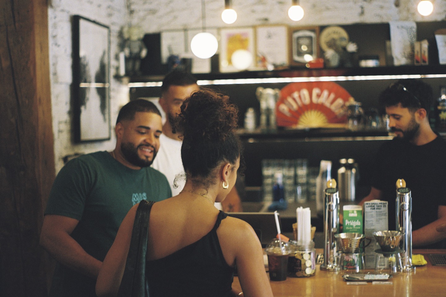 Baristas taking orders at the Mision Cafe counter during the party