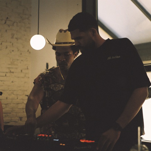 Hands on the DJ controller in warm light